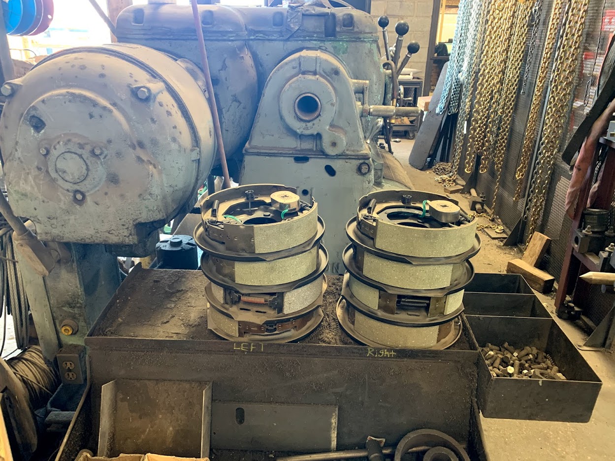 Left and right electric trailer drum brake assemblies staged on a workbench at Riggs Machine & Welding in Stephenville, TX
