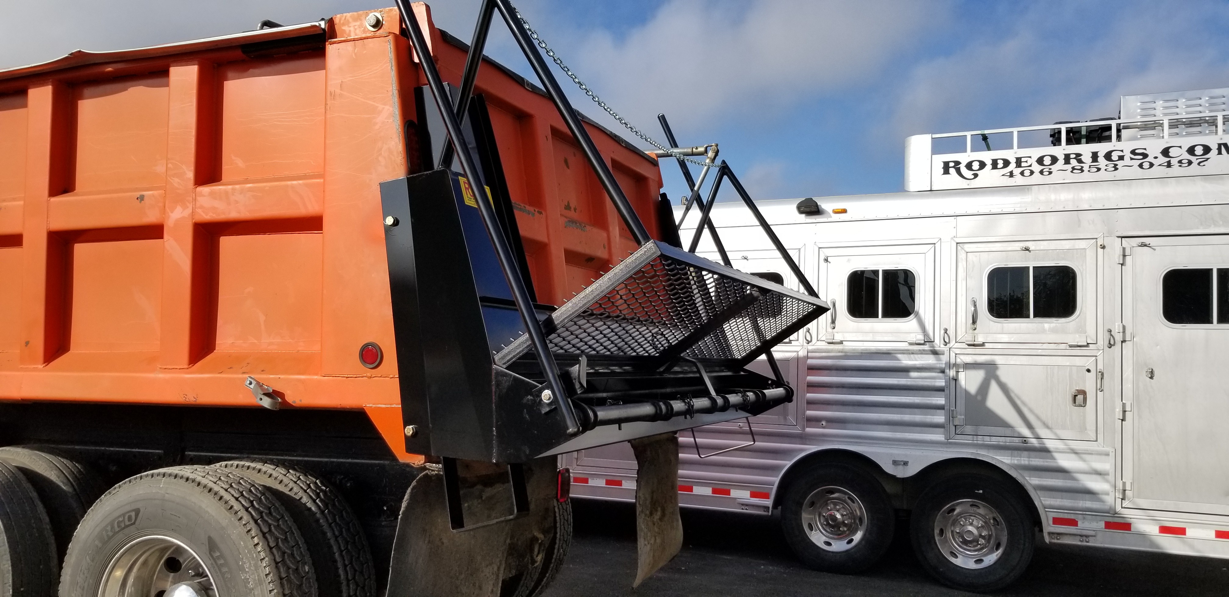Custom chip spreader with fabricated catwalk mounted on the tailgate of an orange dump truck, built by Riggs Machine & Welding in Stephenville, TX